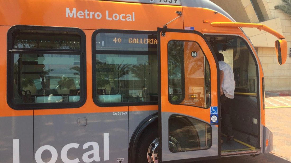 A passenger boarding an orange LA Metro Local bus on route 40